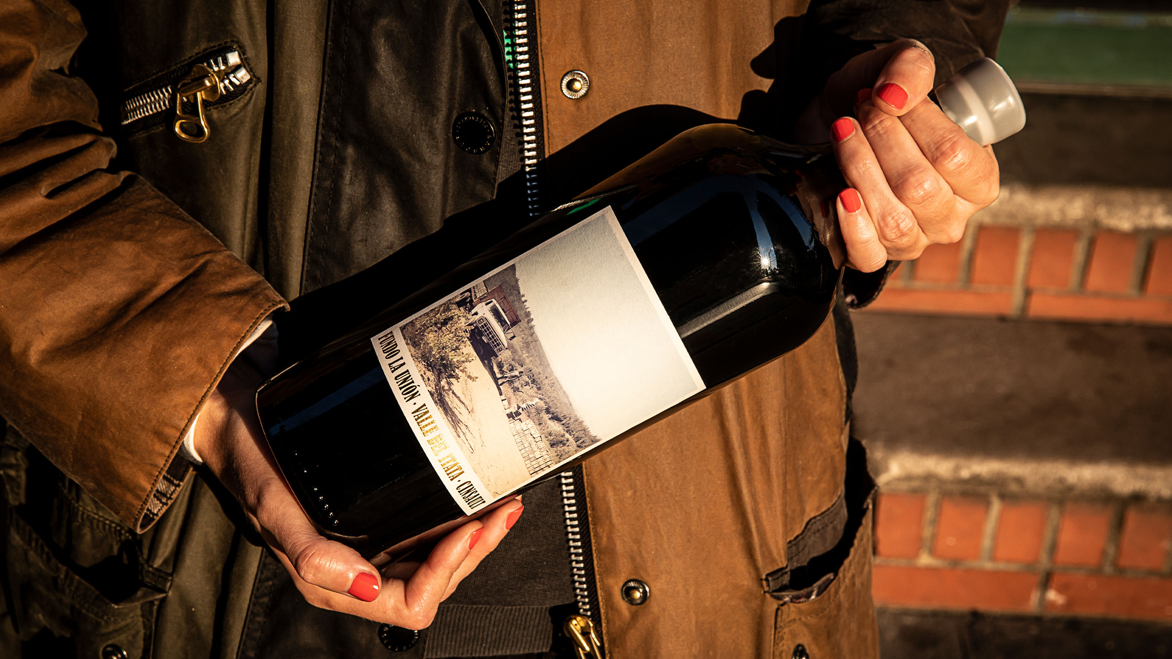 A person holds a bottle of wine