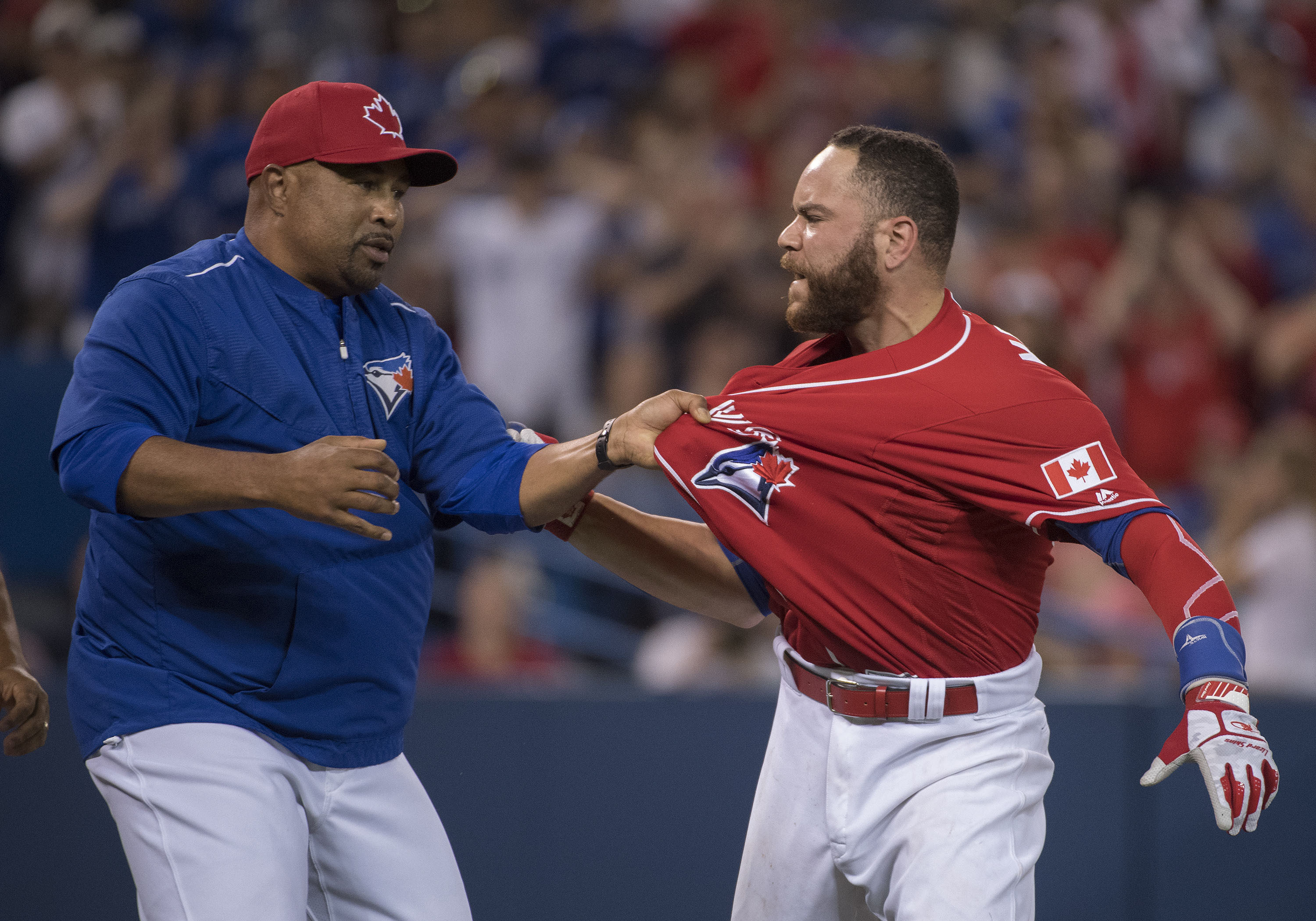 Jul 1, 2016; Toronto, Ontario, CAN; Toronto Blue Jays catcher Russell Martin (55) is restrained by bench coach DeMarlo Hale (16) during the thirteenth inning in a game against the Cleveland Indians at Rogers Centre. The Cleveland Indians won 2-1.