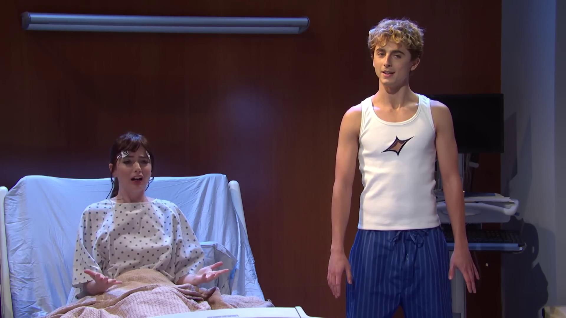 Timothee Chalamet dressed up as the pop star Troye Sivan on Saturday Night Live (SNL). He’s wearing baggy pants and a tight white shirt. 