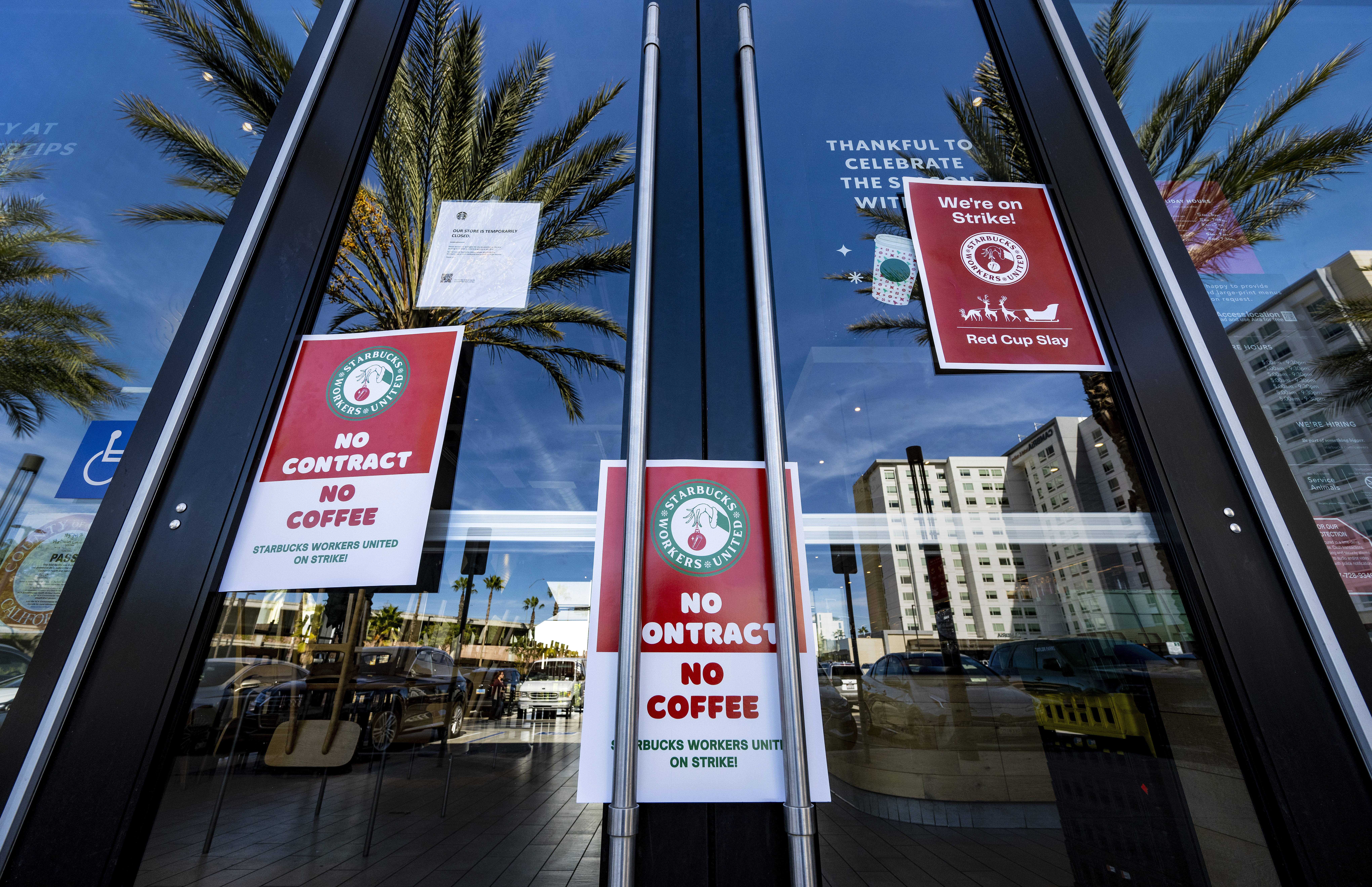 Signs reading “no contract, no coffee” in the glass doors of a Starbucks