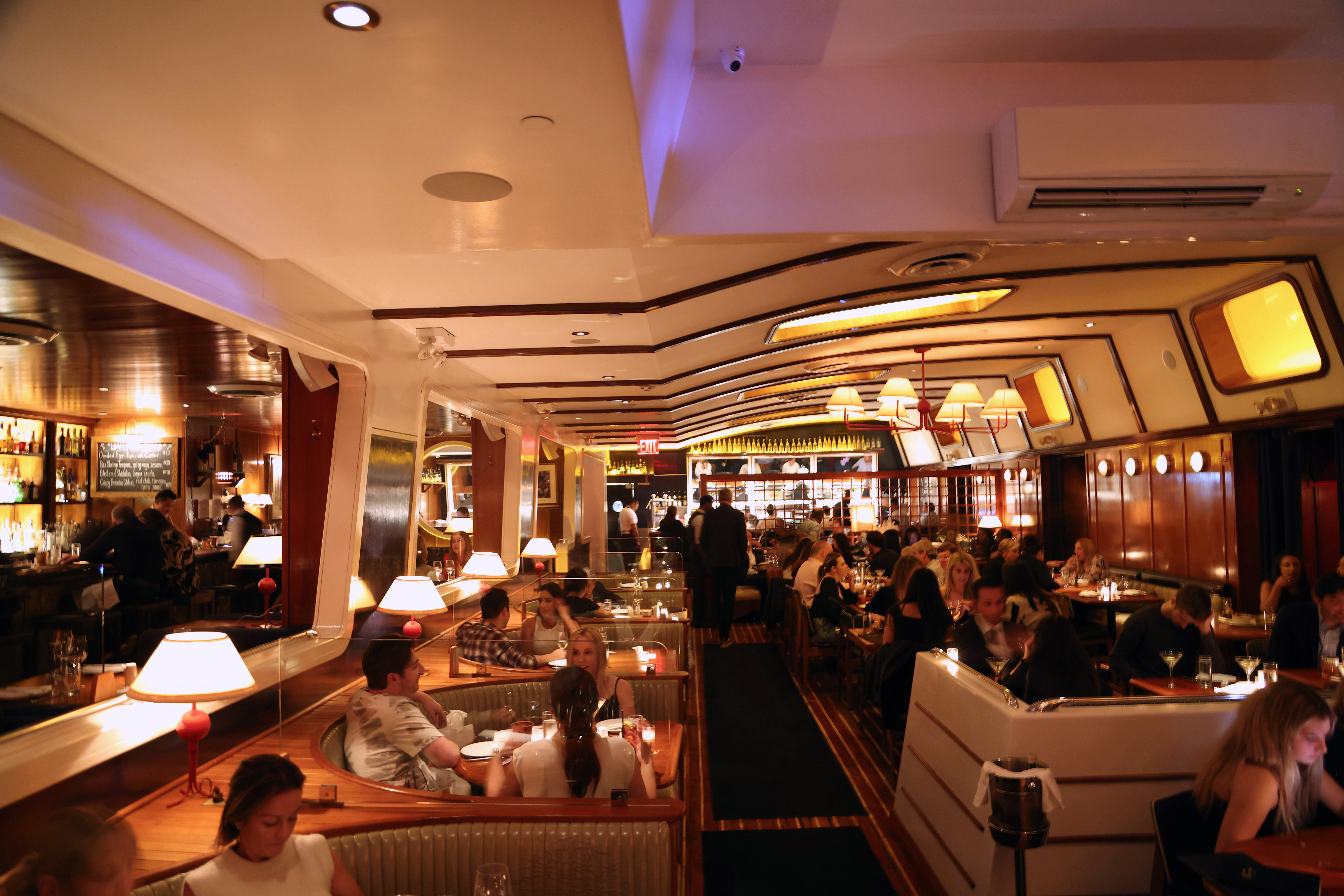 The interior of a restaurant full of people looks like the inside of a boat.
