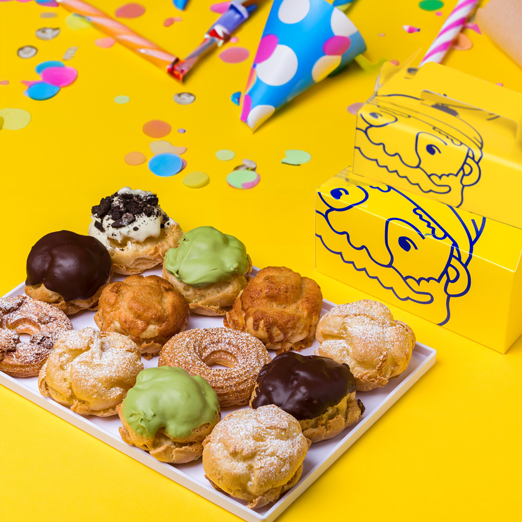 A tray of cream puffs on a yellow table.