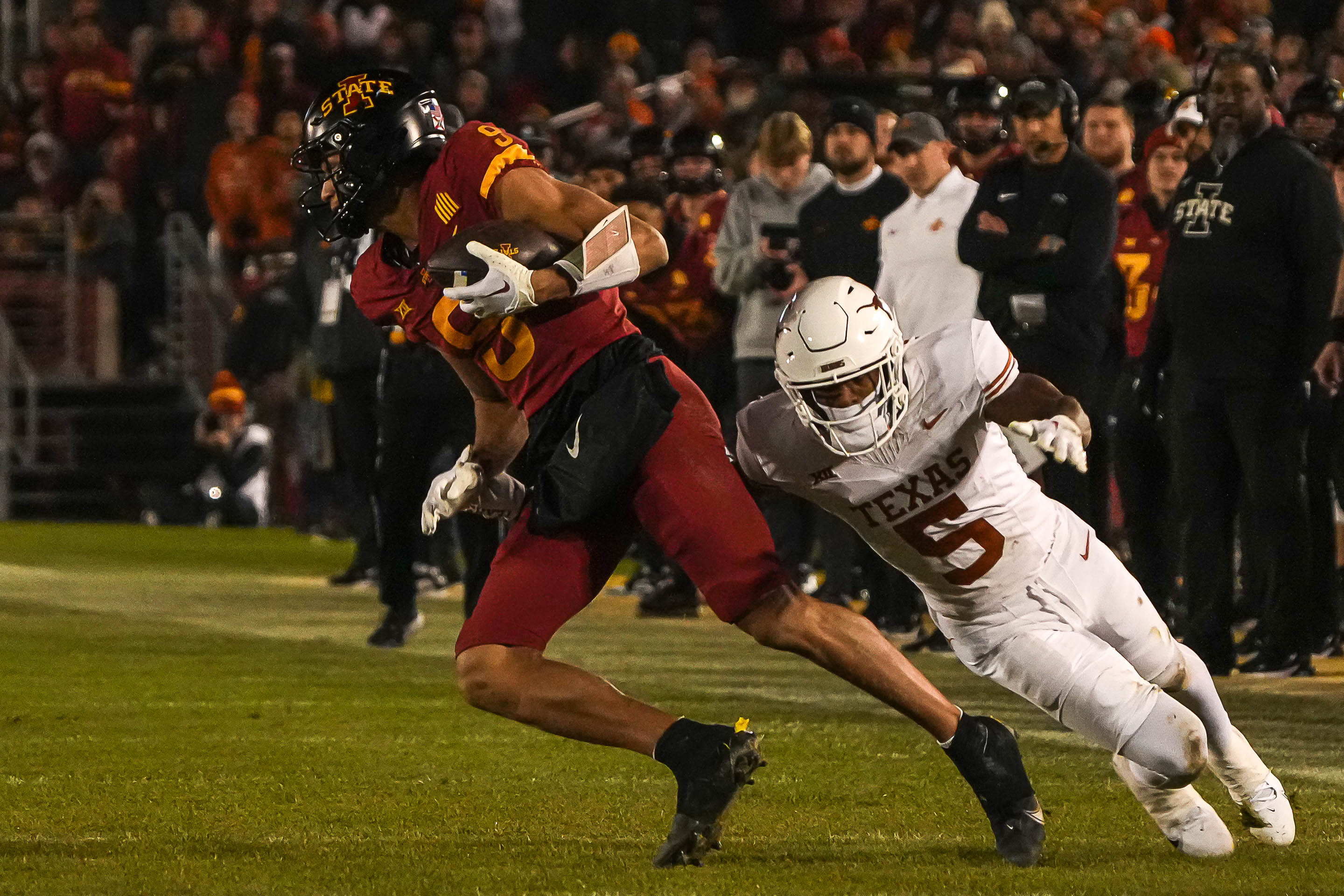 Nov 18, 2023; Ames, Iowa, USA; Iowa State Cyclones wide receiver Jayden Higgins (9) tries to avoid Texas Longhorns defensive back Malik Muhammad (5) during the game at Jack Trice Stadium.