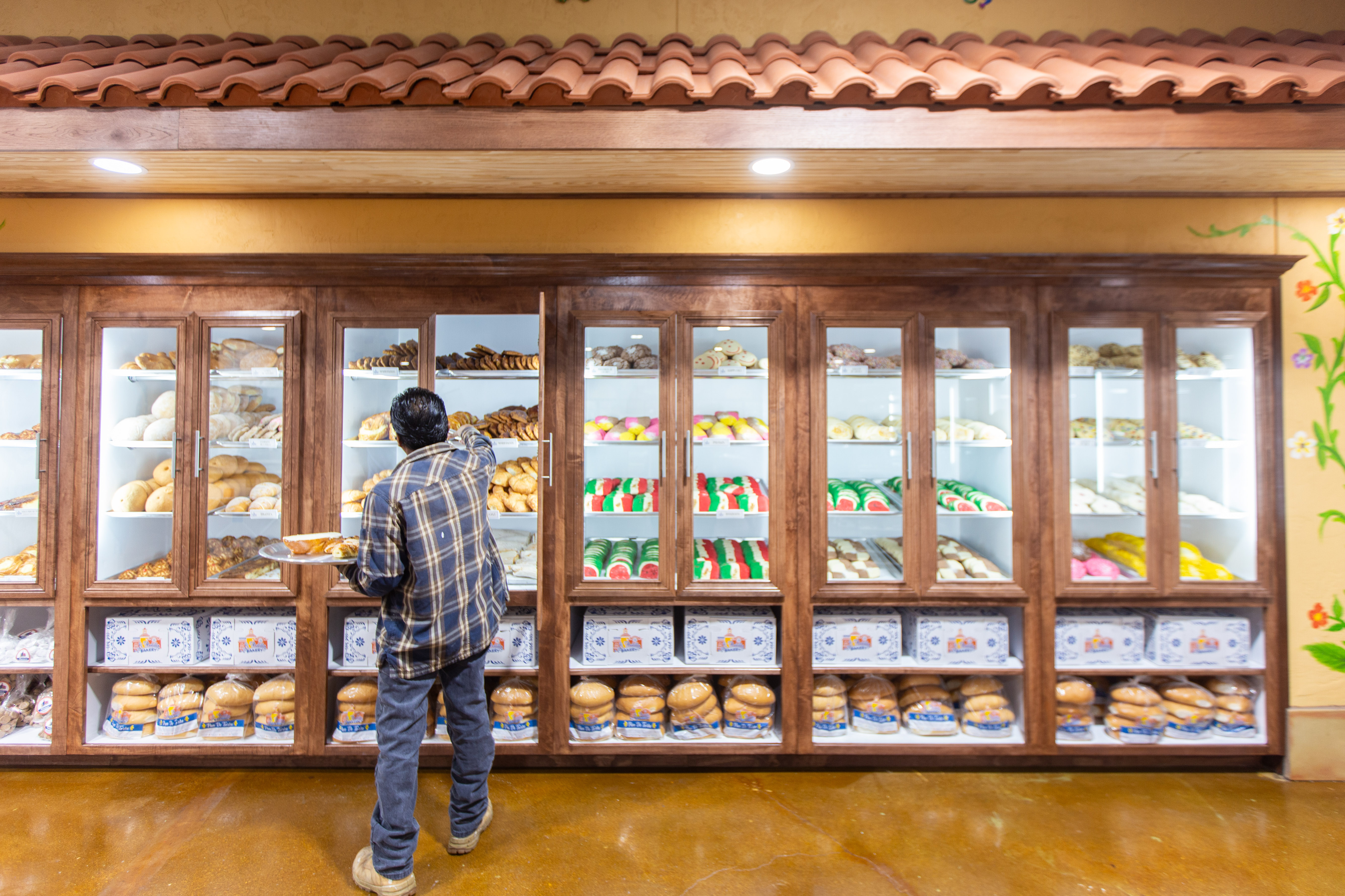 A man loads up the bakery shelves at El Bolillo bakery.