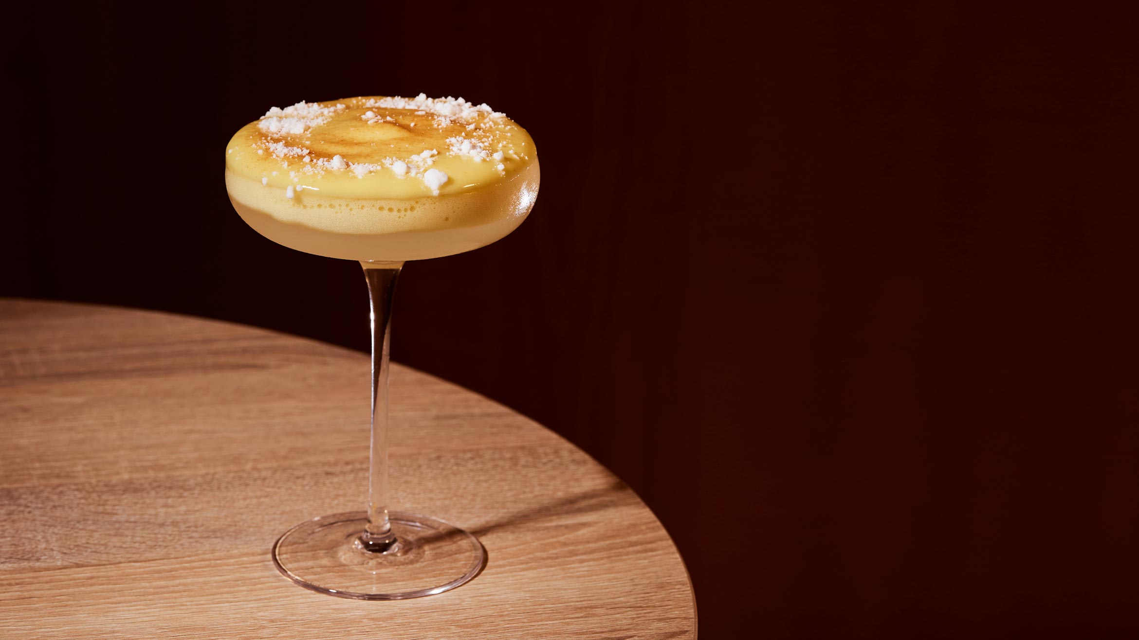 A mango sticky rice-inspired cocktail in a glass with a long stem
