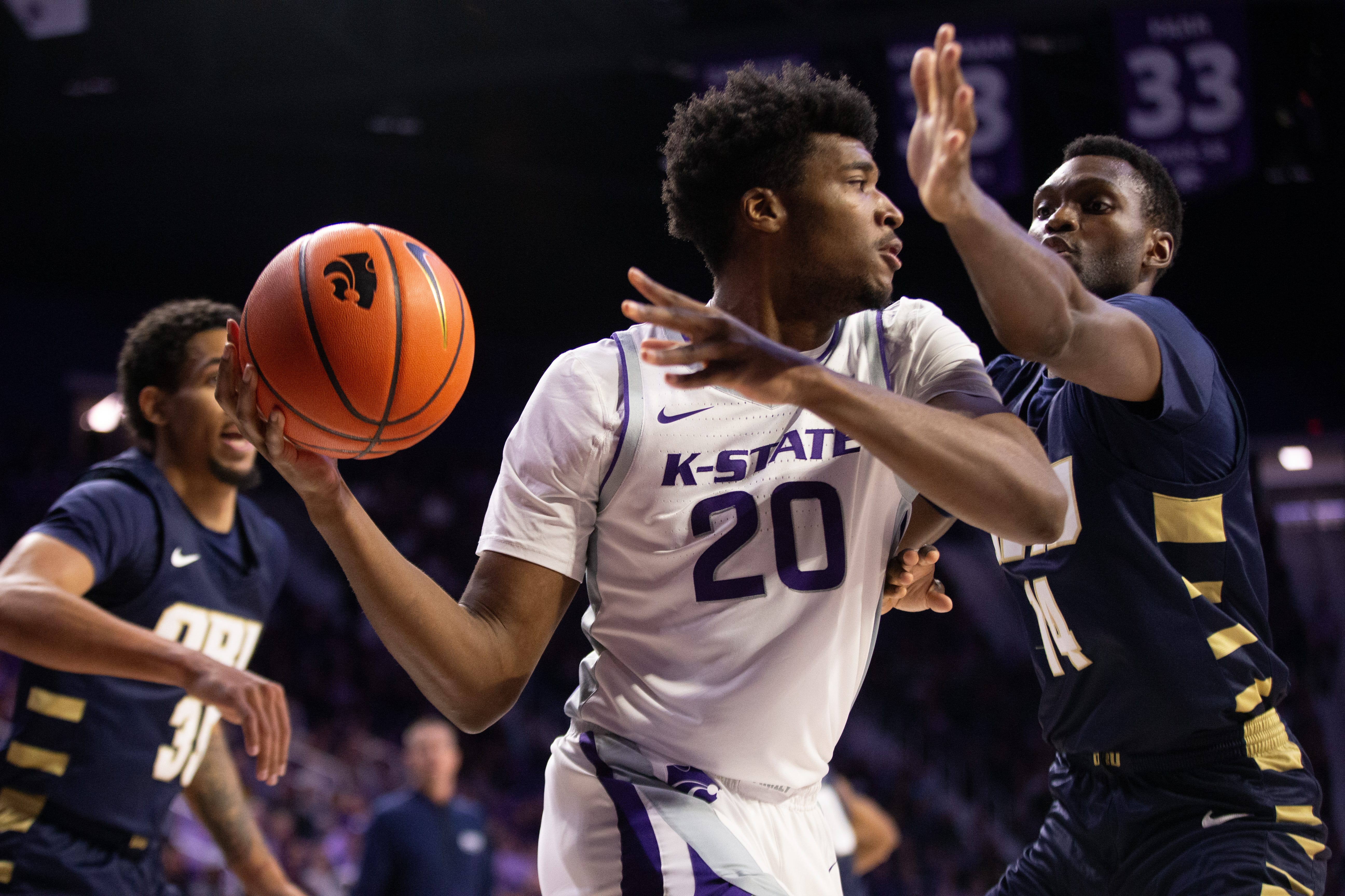 Kansas State redshirt sophomore wing Jerrell Colbert (20) looks for a pass around Oral Roberts graduate forward Deshang Weaver (14) during the first half of Tuesday’s game inside Bramlage Coliseum.