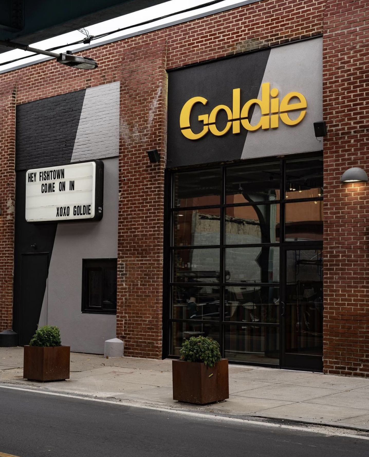 A storefront with a yellow sign reading “Goldie”
