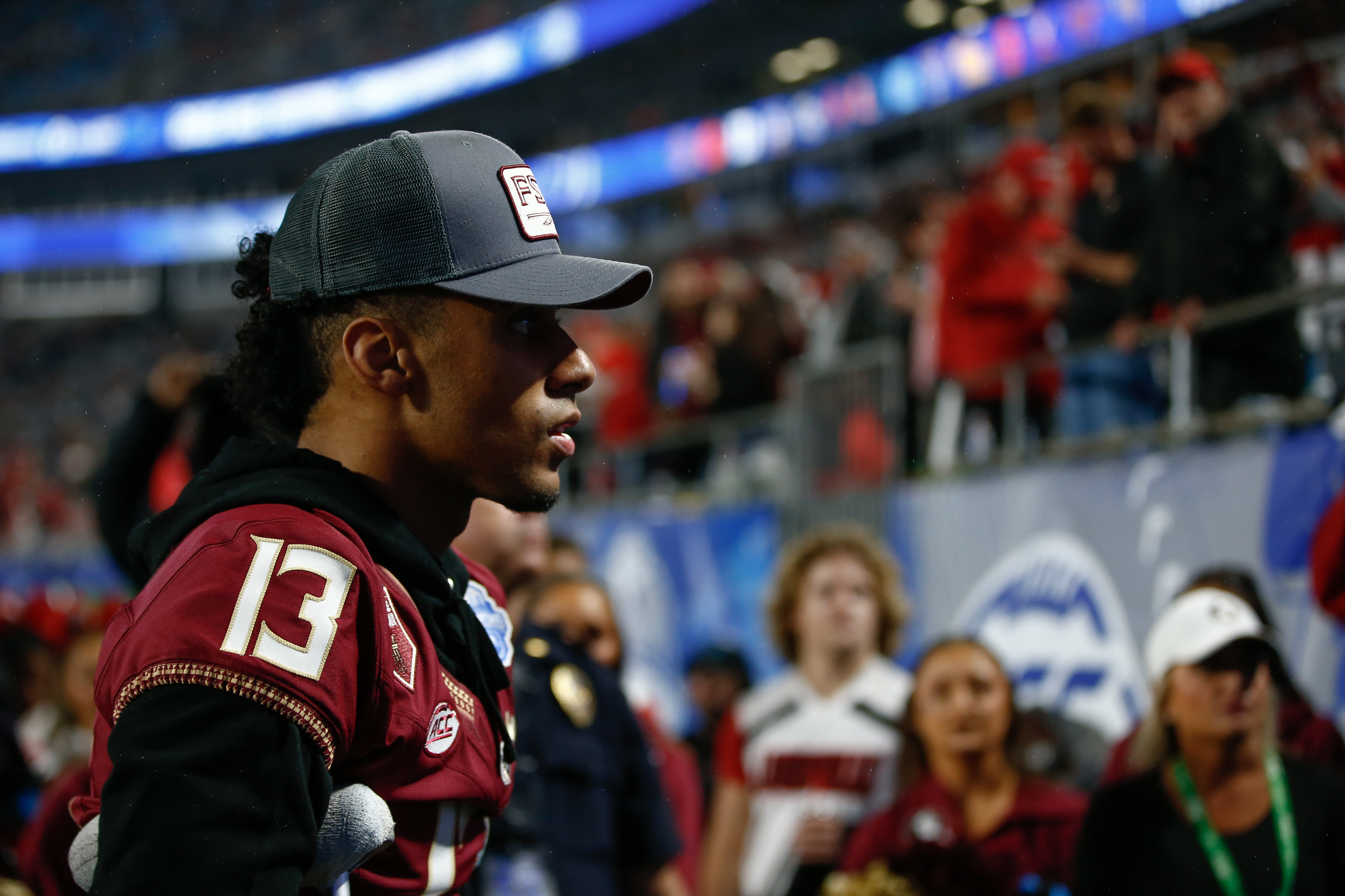 Jordan Travis #13 of the Florida State Seminoles walks off the field after the first half against the Louisville Cardinals during the ACC Championship at Bank of America Stadium on December 2, 2023 in Charlotte, North Carolina.