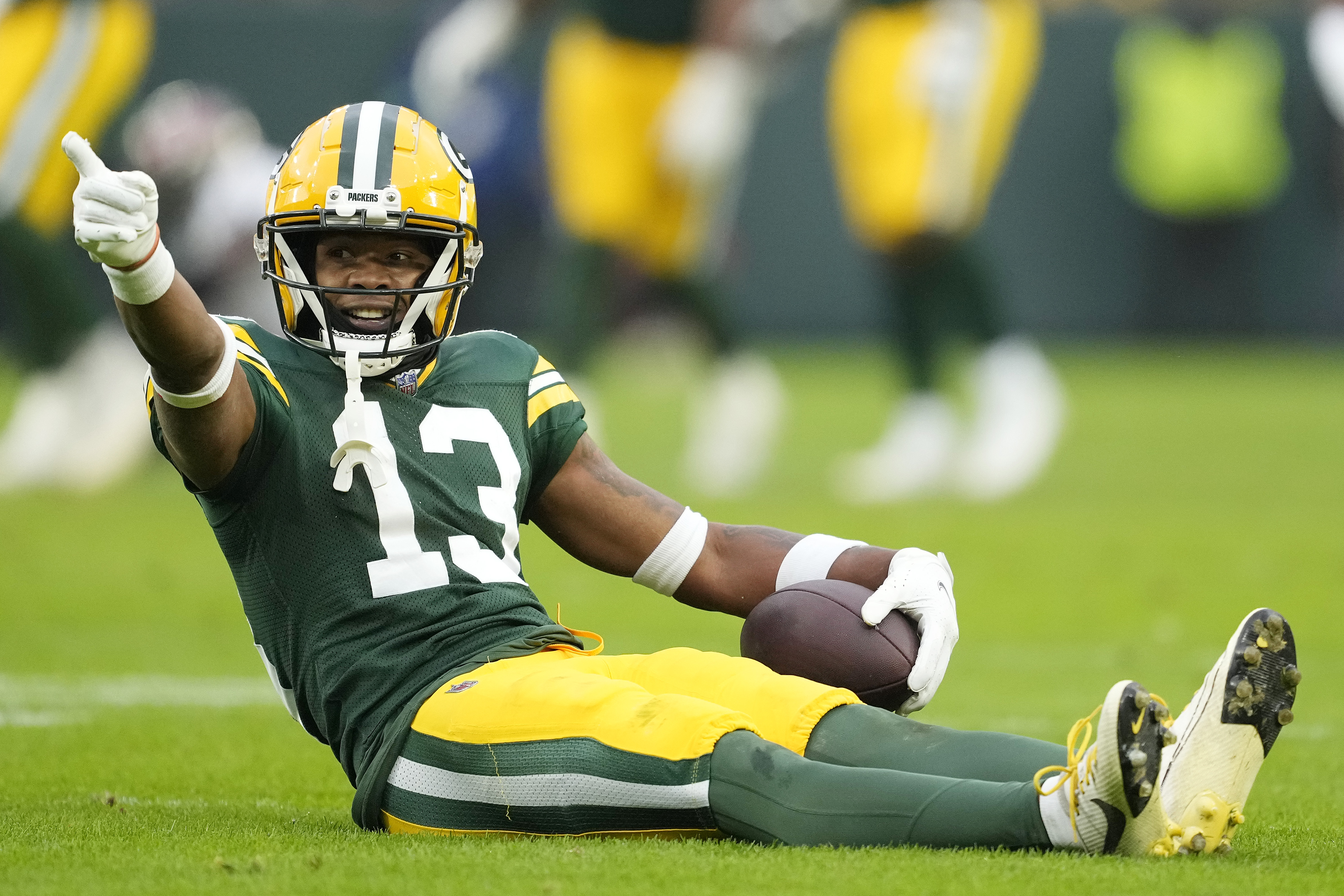 Dontayvion Wicks of the Green Bay Packers signals for a first down during the second half against the Tampa Bay Buccaneers at Lambeau Field on December 17, 2023 in Green Bay, Wisconsin.