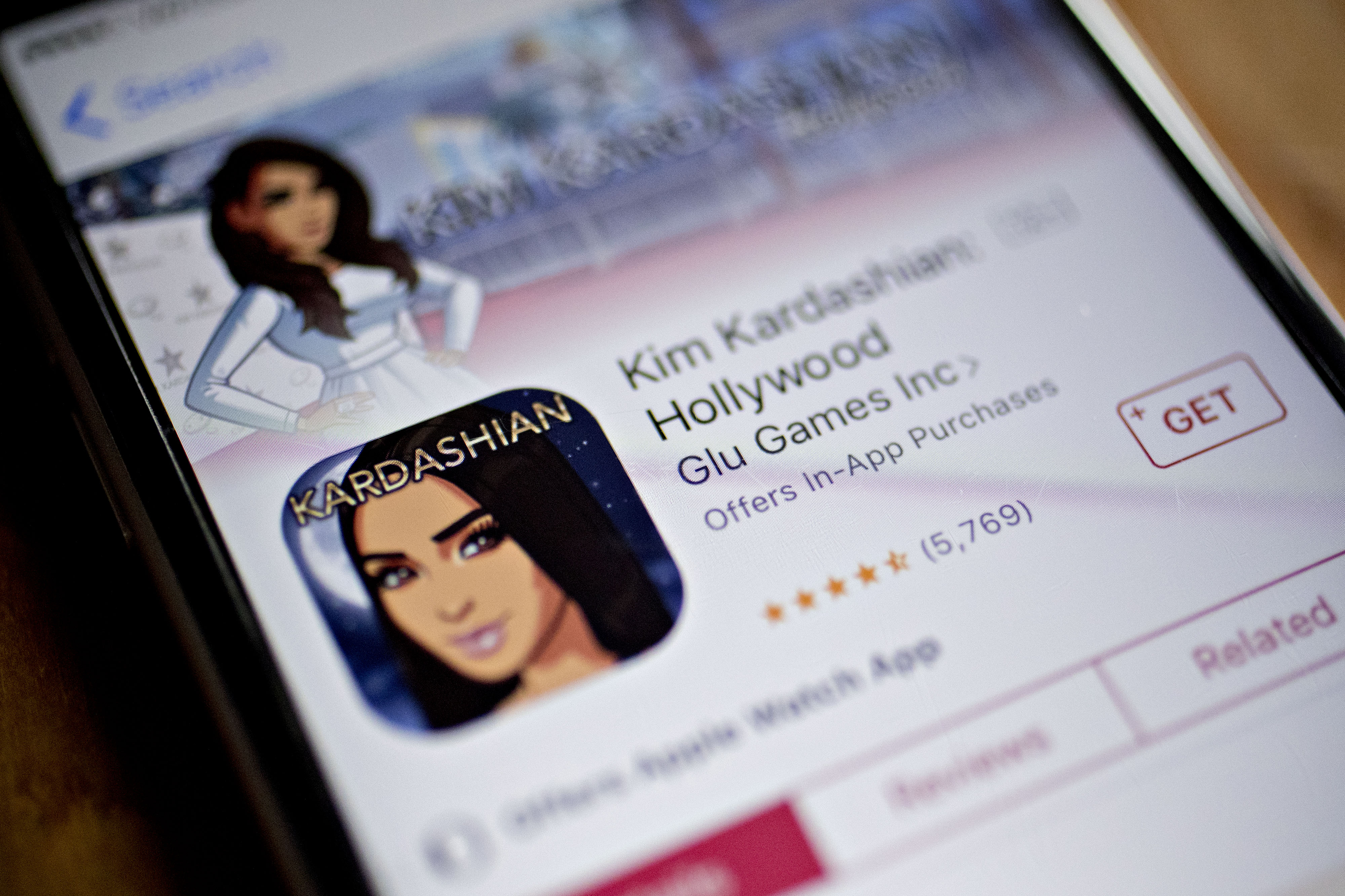 A photograph of a phone with the Kim Kardashian: Hollywood mobile store page pulled up.