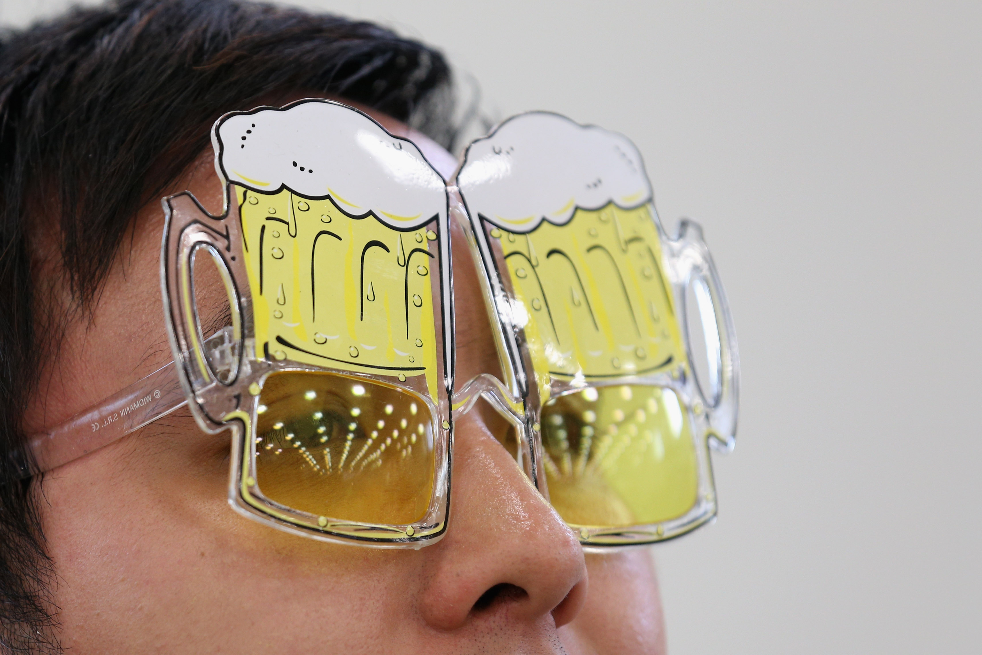 A person wearing glasses shaped like beer mugs.