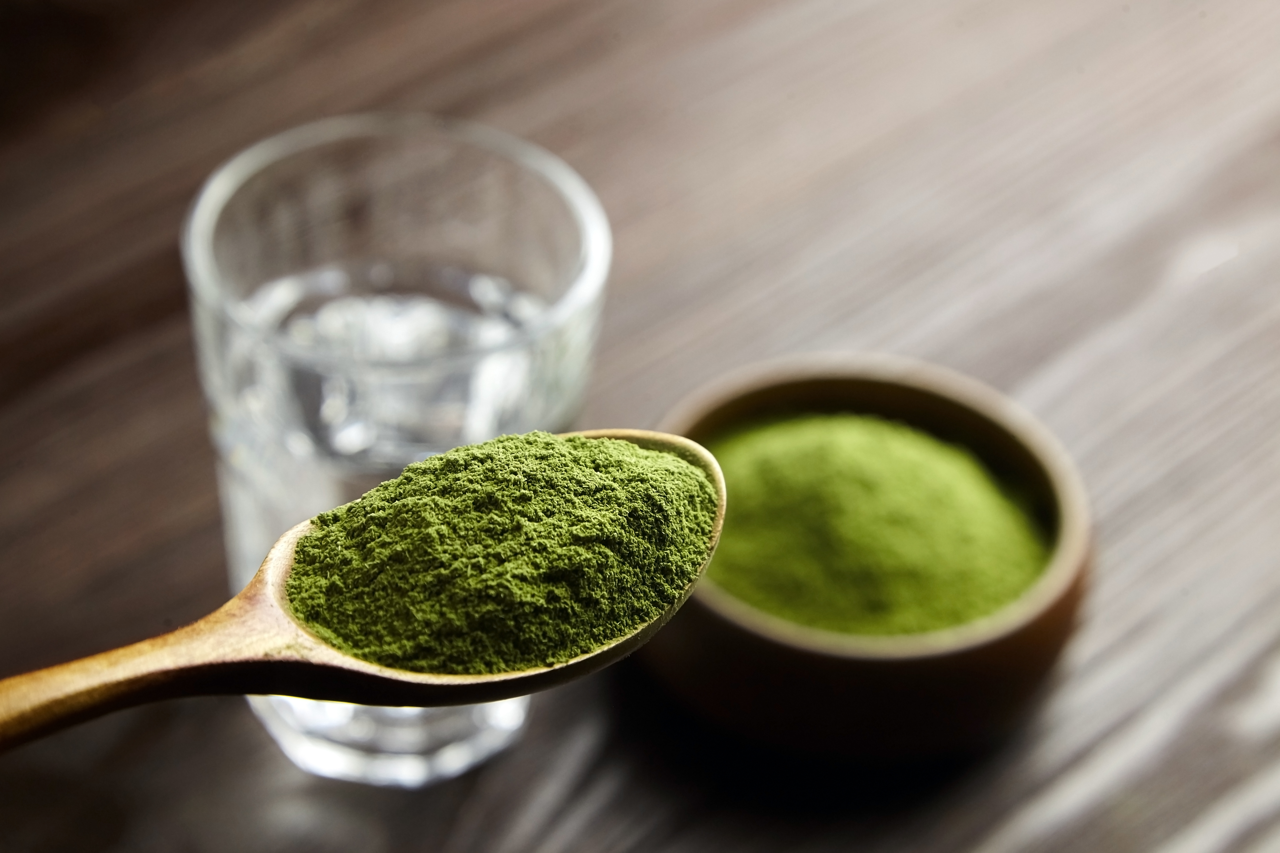 A spoonful of greens powder in a wooden spoon