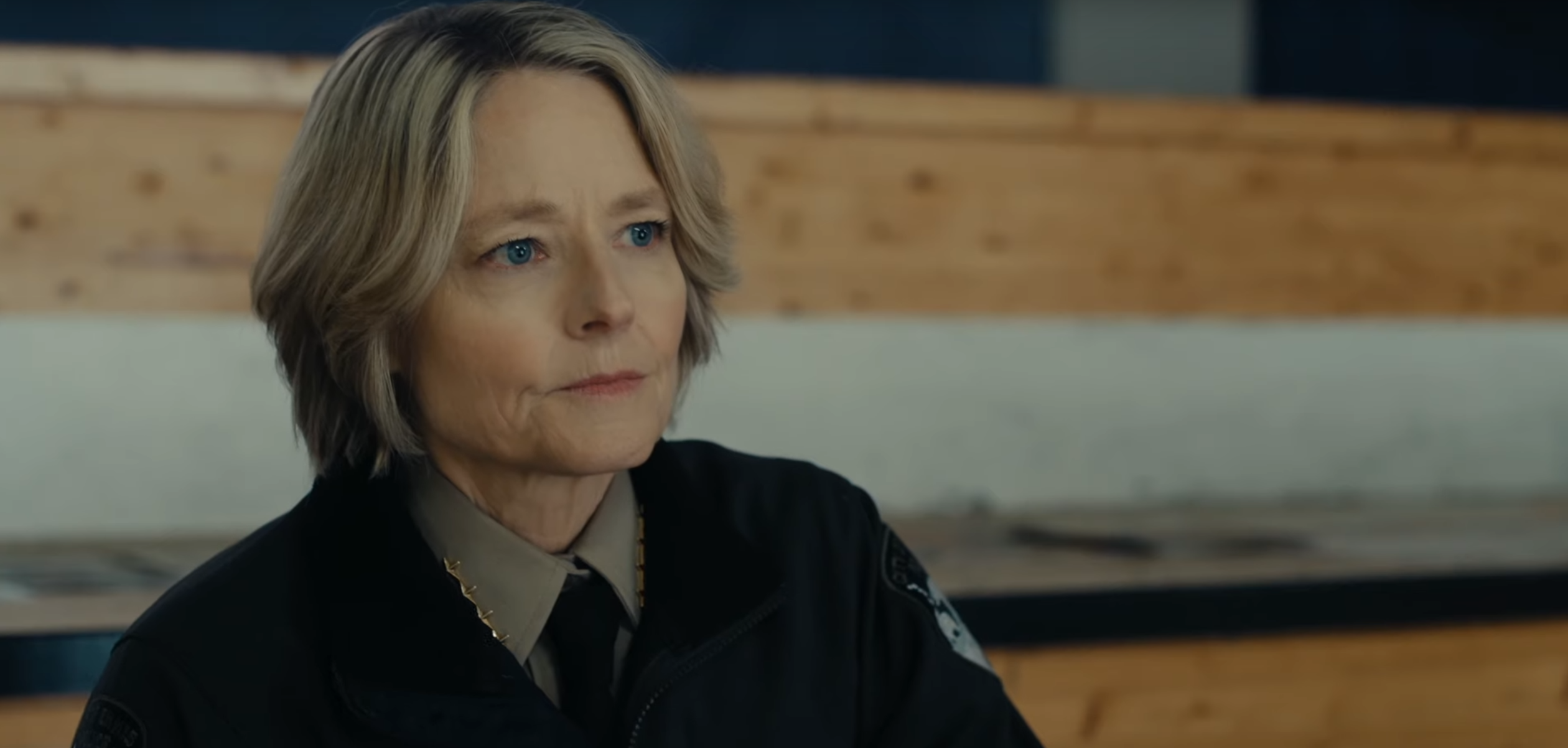Jodie Foster sitting on a bench in a police uniform in True Detective: Night Country