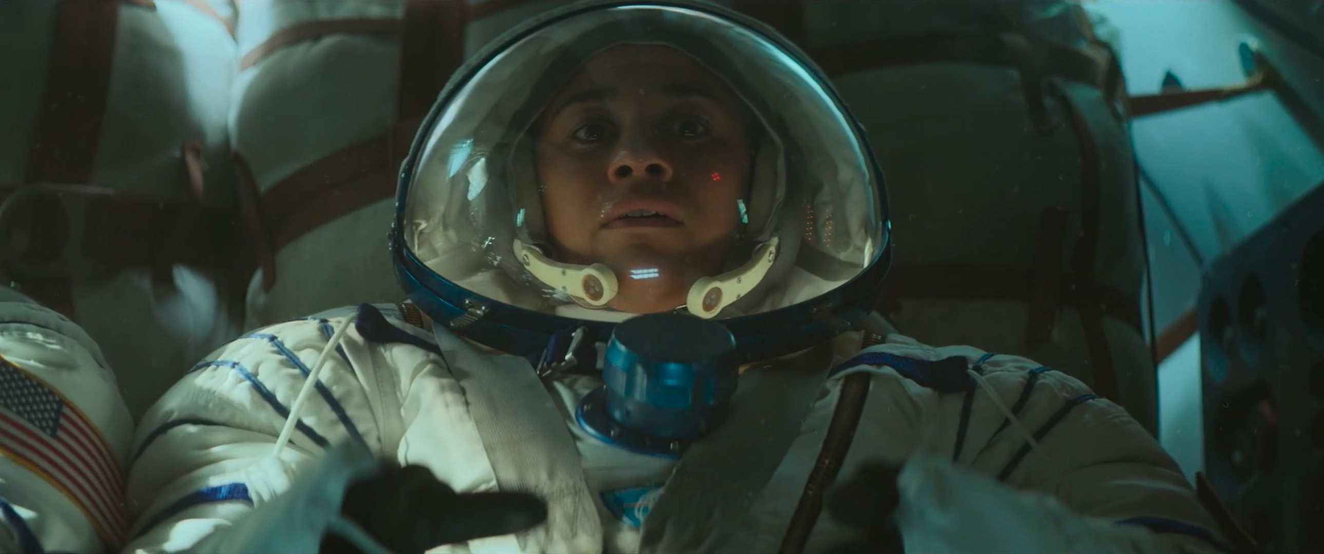 Dr. Kira Foster (Ariana DeBose) looks nervous in her full-body spacesuit and helmet in a close-up shot in I.S.S.