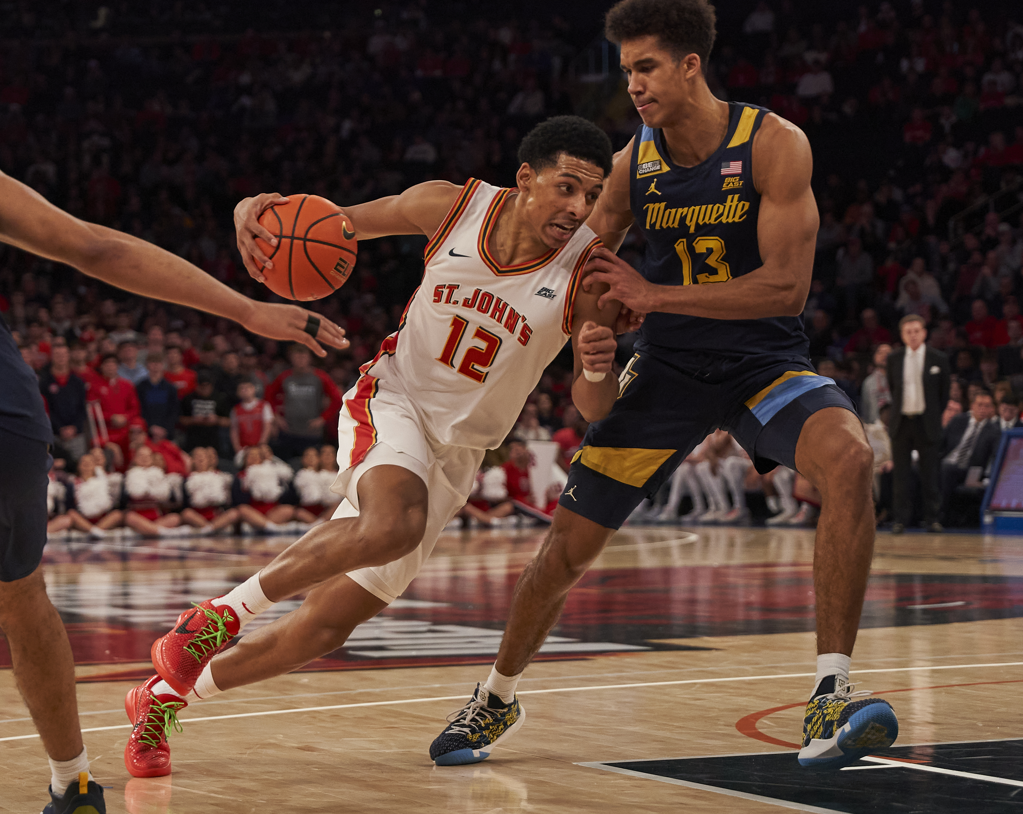St. John’s Red Storm player R.J. Luis (12) dribbles into Marquette Golden Eagles player Oso Ighodaro (13) in game at Madison Square Garden on Saturday, January 20, 2024