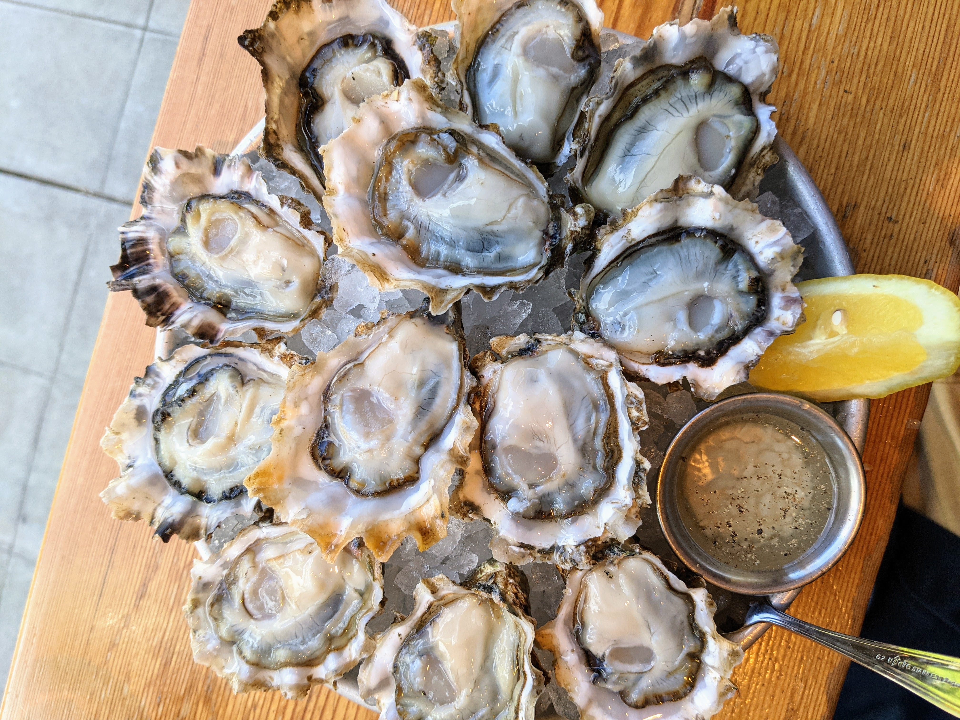 Raw oysters with mignonette sauce and lemon over ice.
