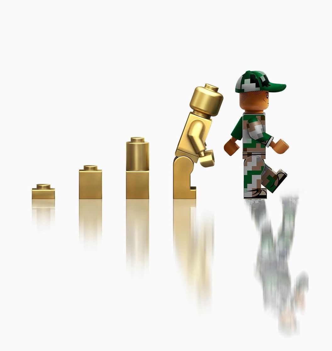Pharrell as Lego in the dawn of man type graphic with gold lego pieces behind him