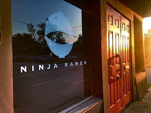 A store window and doors shot at sunset on an angle. The window reads “Ninja Ramen.”