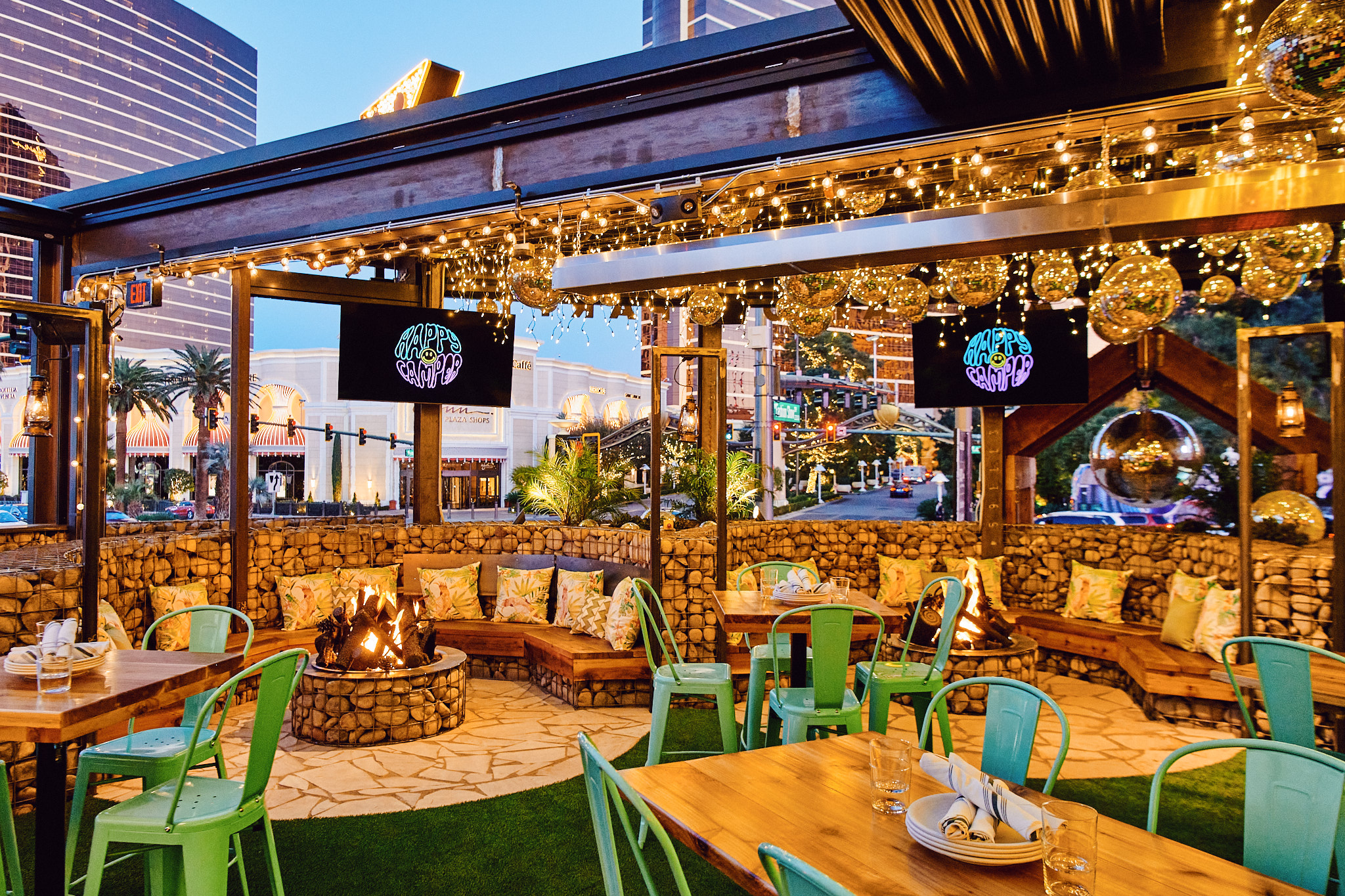 A patio with disco balls, fire pits, and TVs.