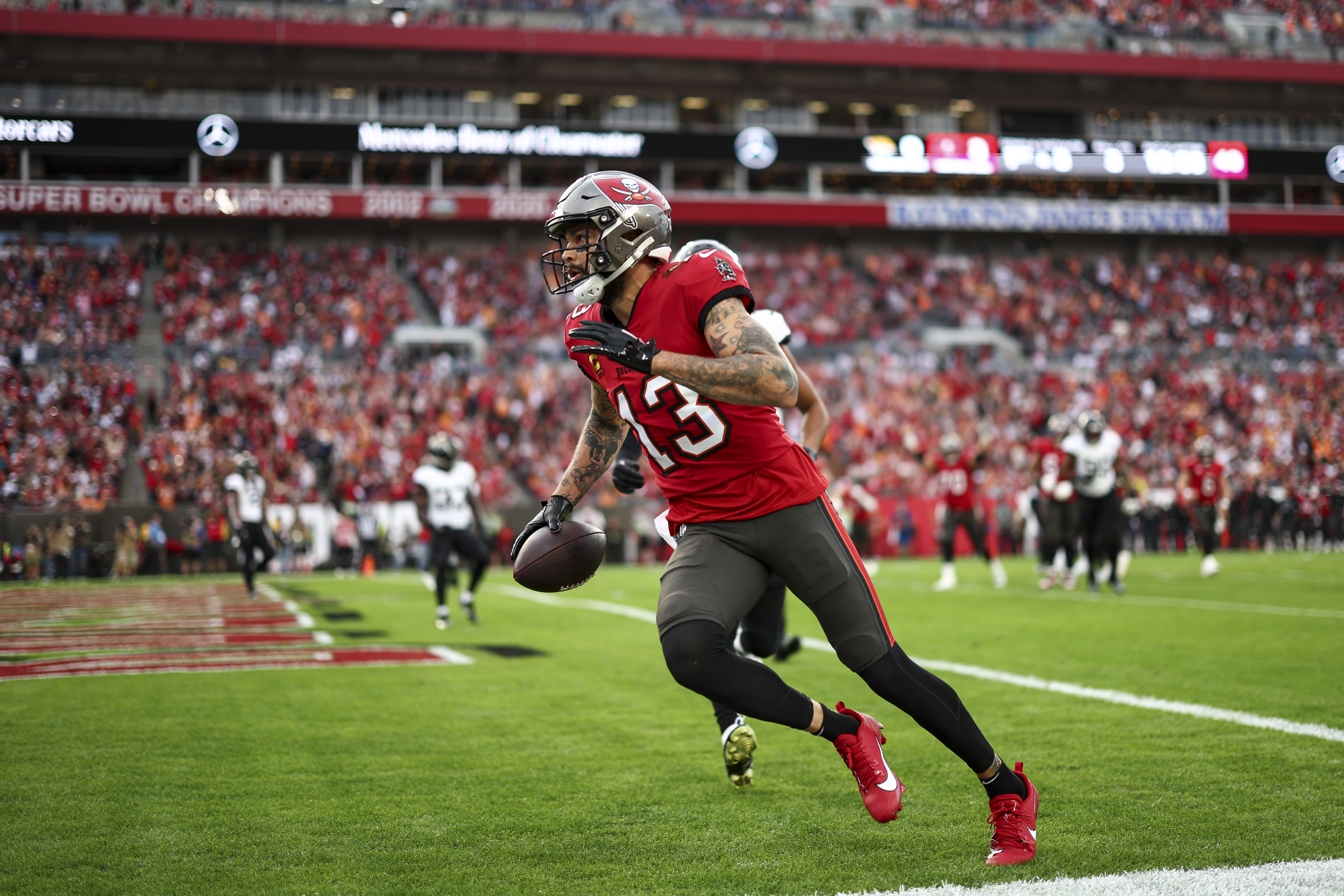 Mike Evans #13 of the Tampa Bay Buccaneers scores a touchdown during the second quarter of an NFL football game against the Jacksonville Jaguars at Raymond James Stadium on December 24, 2023 in Tampa, Florida.