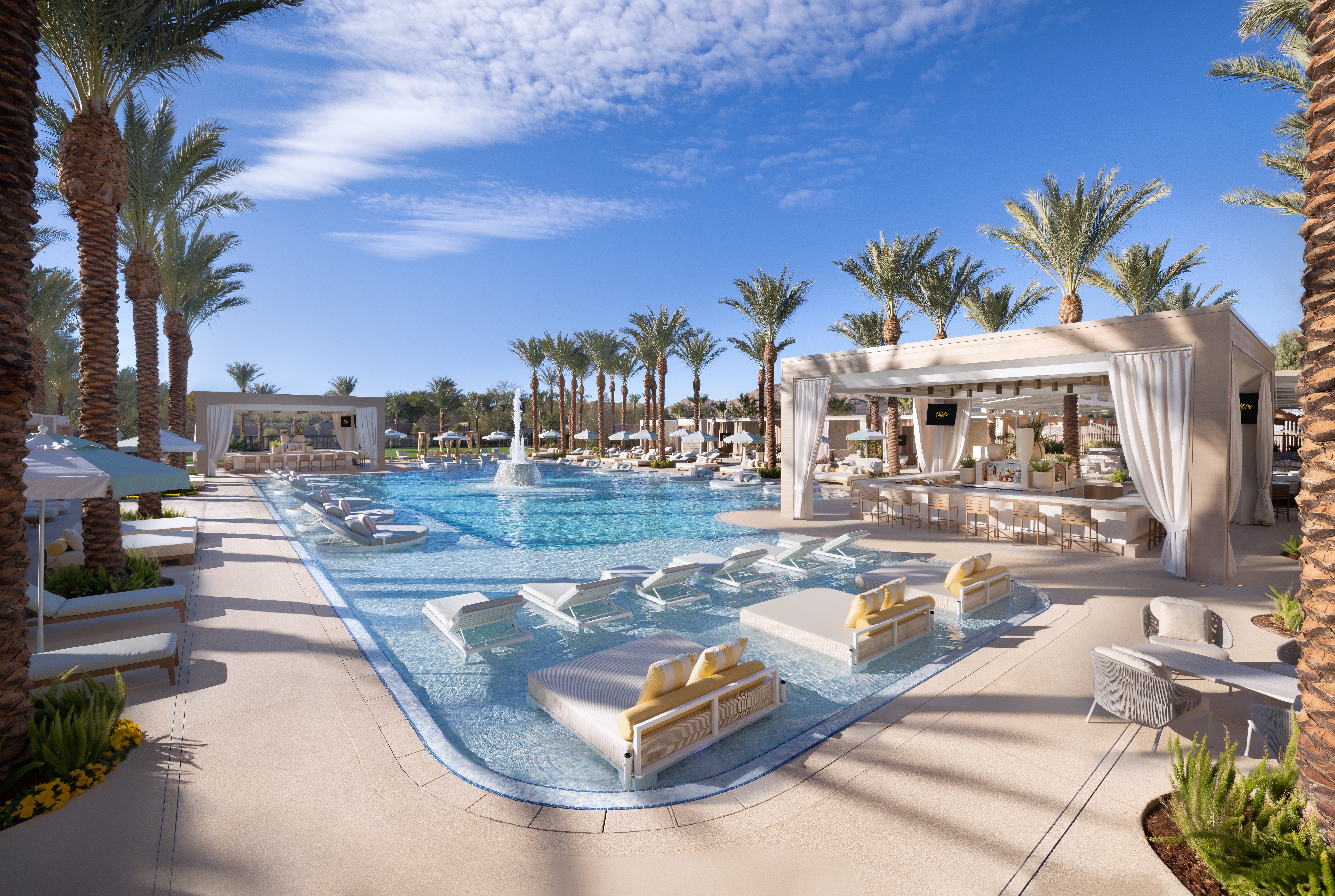 A pool with lounges and cabanas.