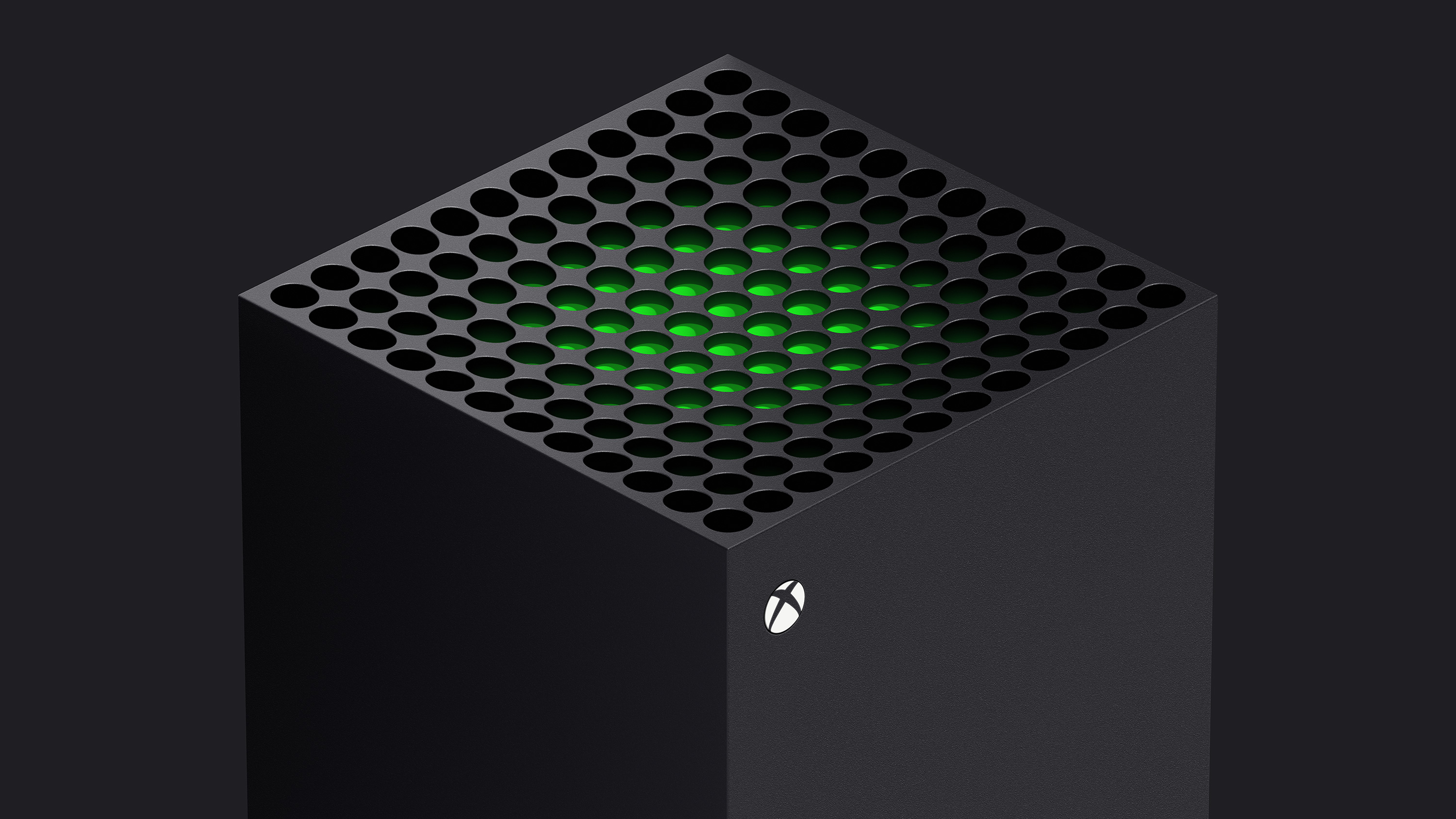 a three-quarters view of the top of the Xbox Series X, with a green piece of plastic visible just beneath the system vents