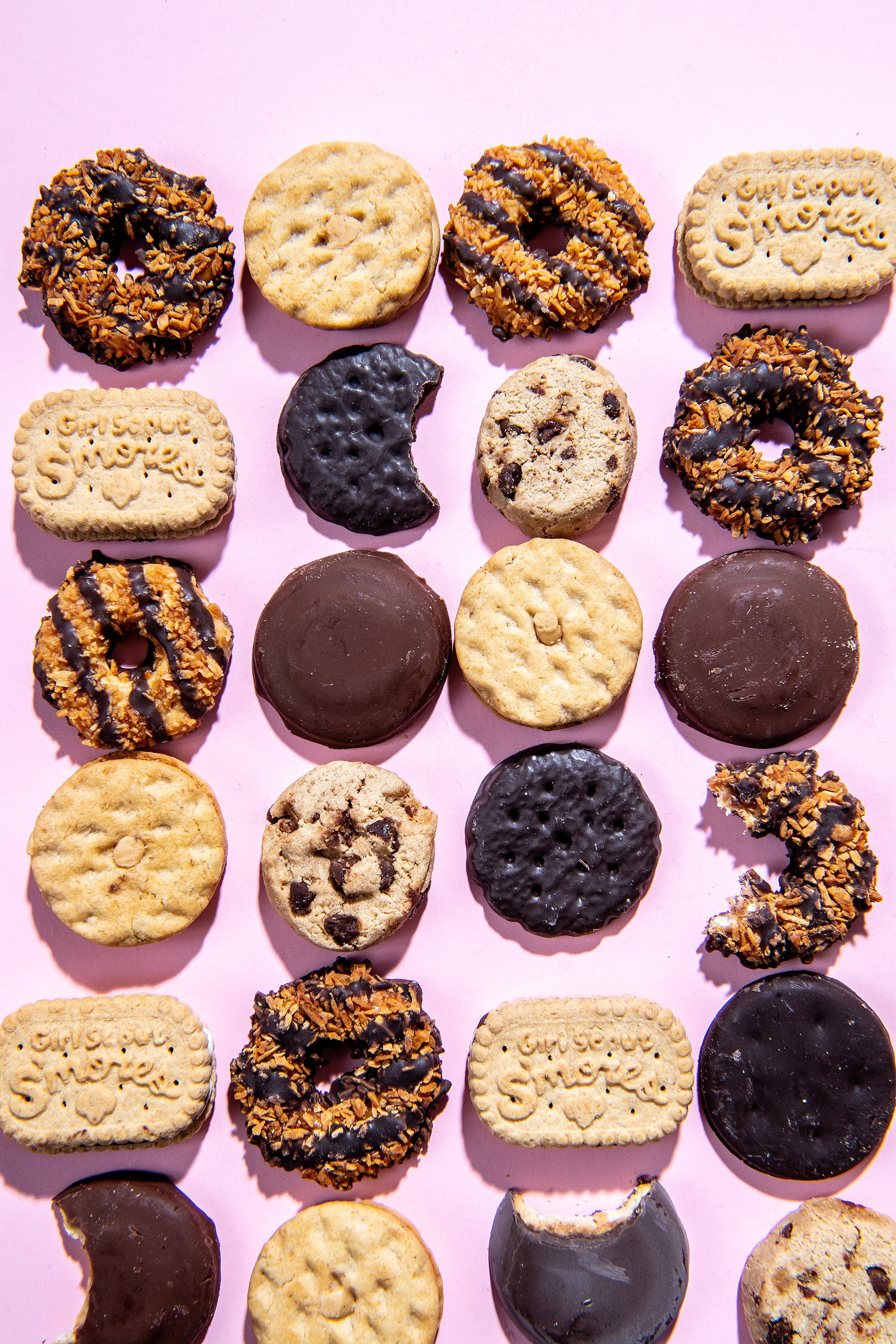 Array of Girl Scout cookies on a pink background.