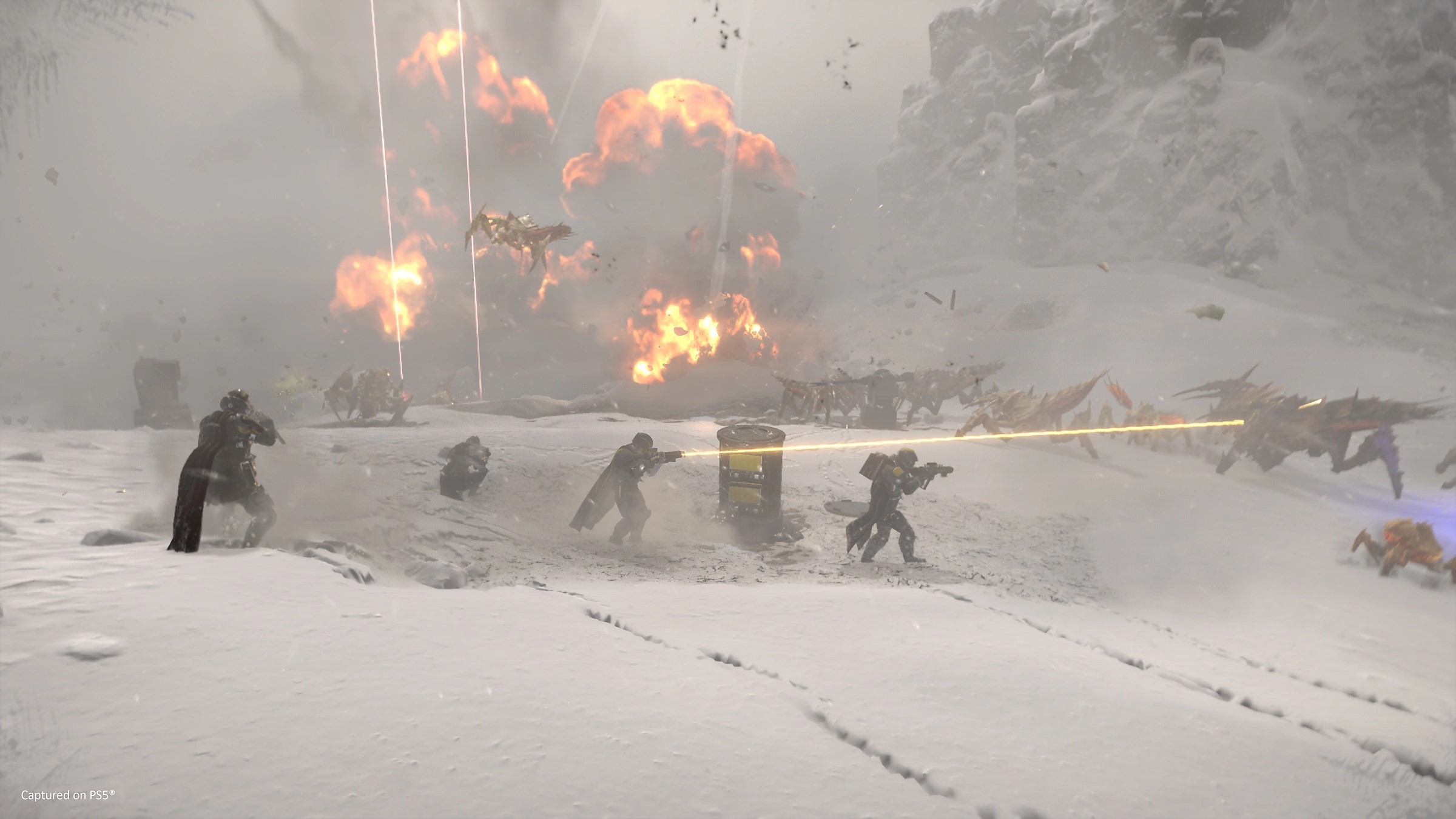 Helldivers carrying guns battle alien bugs in a snowy landscape, with explosions in the background