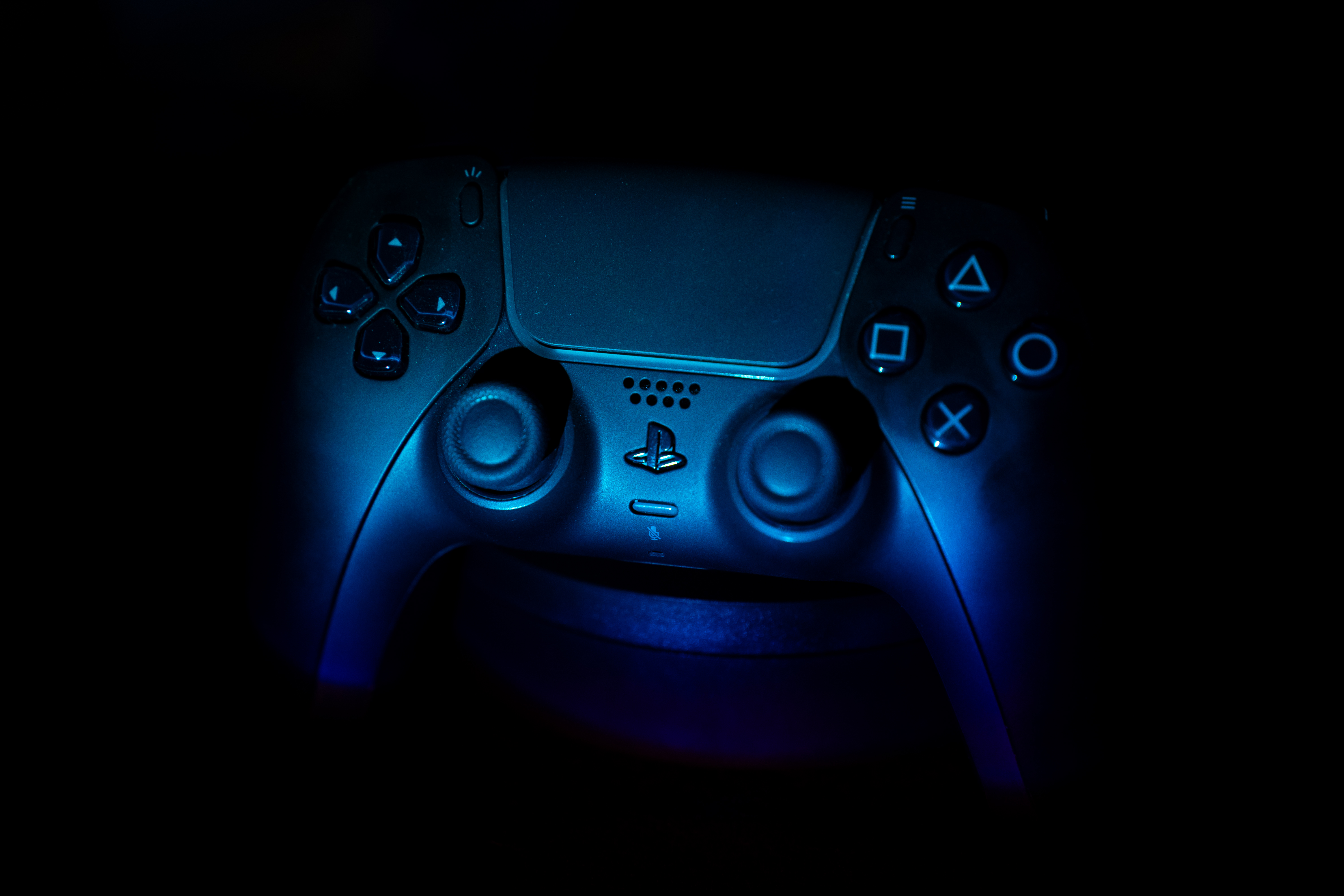 A Midnight Black DualSense wireless gaming controller is being displayed for the PS5 console.