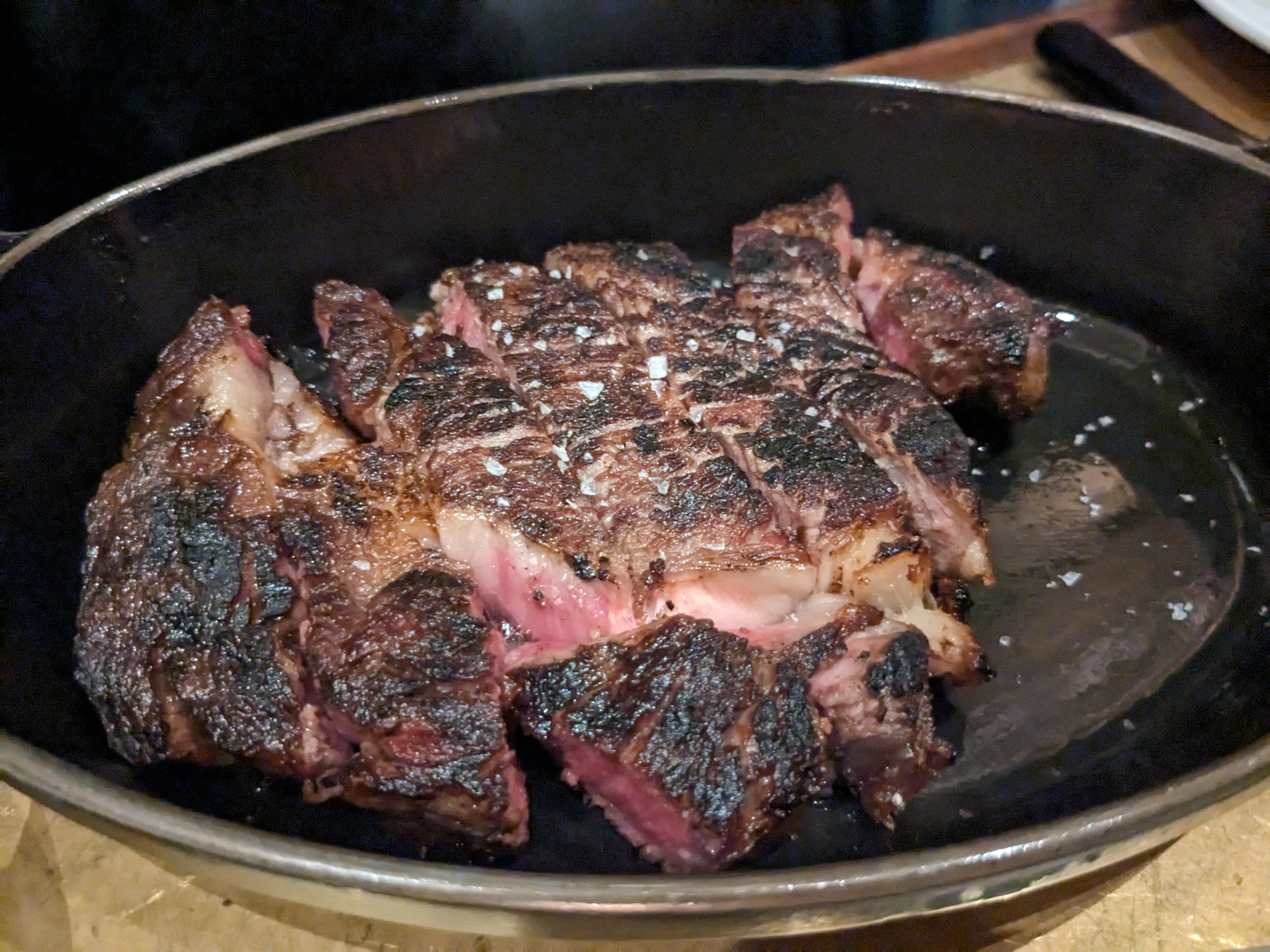 A blackened steak with a bone faintly visible.
