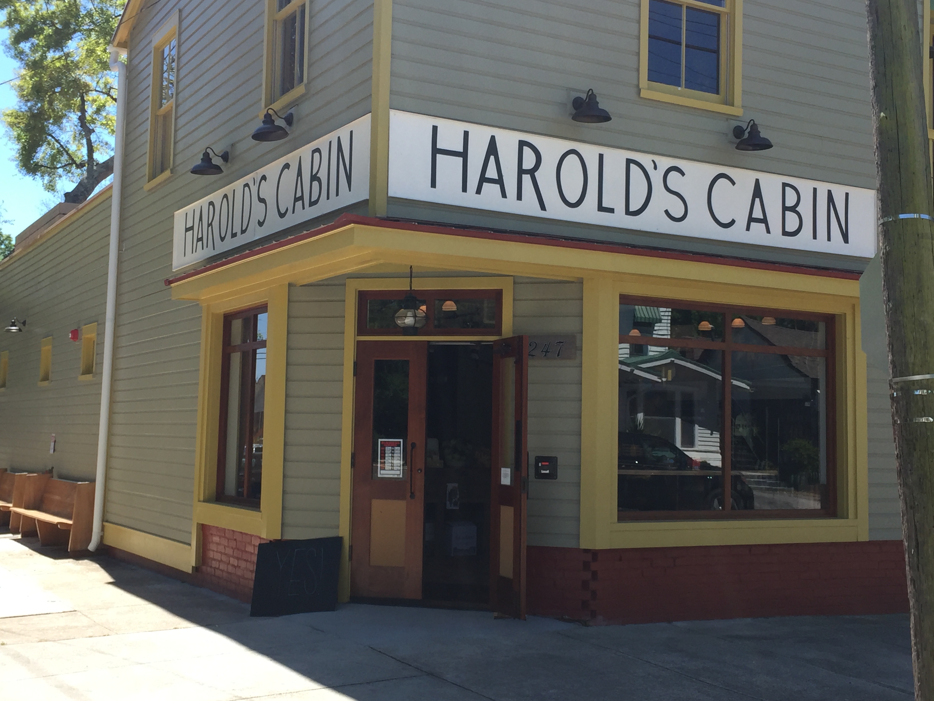 An exterior of a corner building with a sign that says Harold’s Cabin.