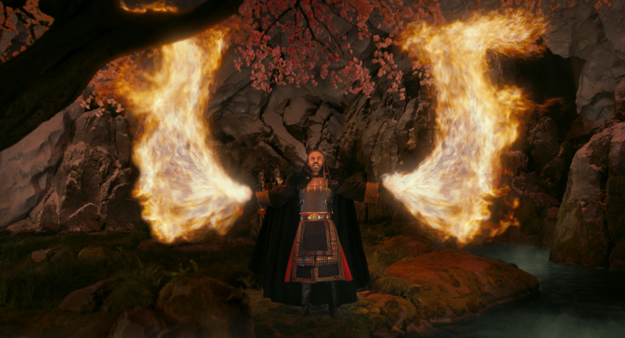Shaun Toub as Uncle Iroh spreads his arms as flames roar from his hands in huge fiery wings in The Last Airbender (2010).