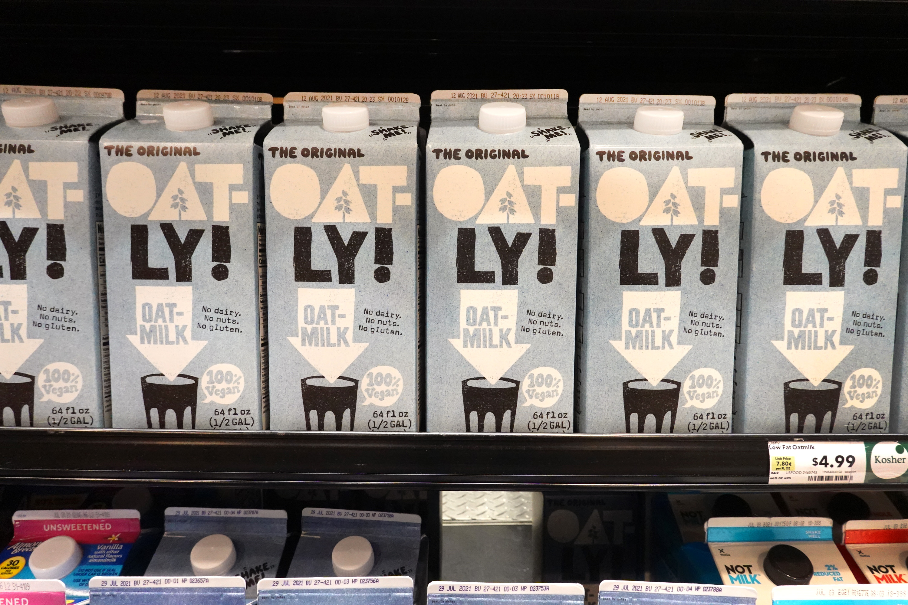 Oat-ly oat milk cartons on a grocery store shelf
