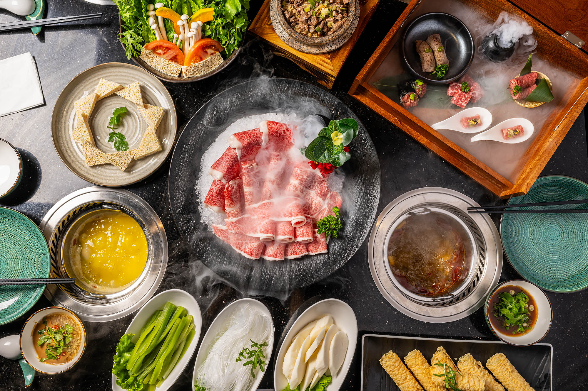 An overhead photograph of raw meat on a plate surrounded by soup and vegetables at Prime Hot Pot.