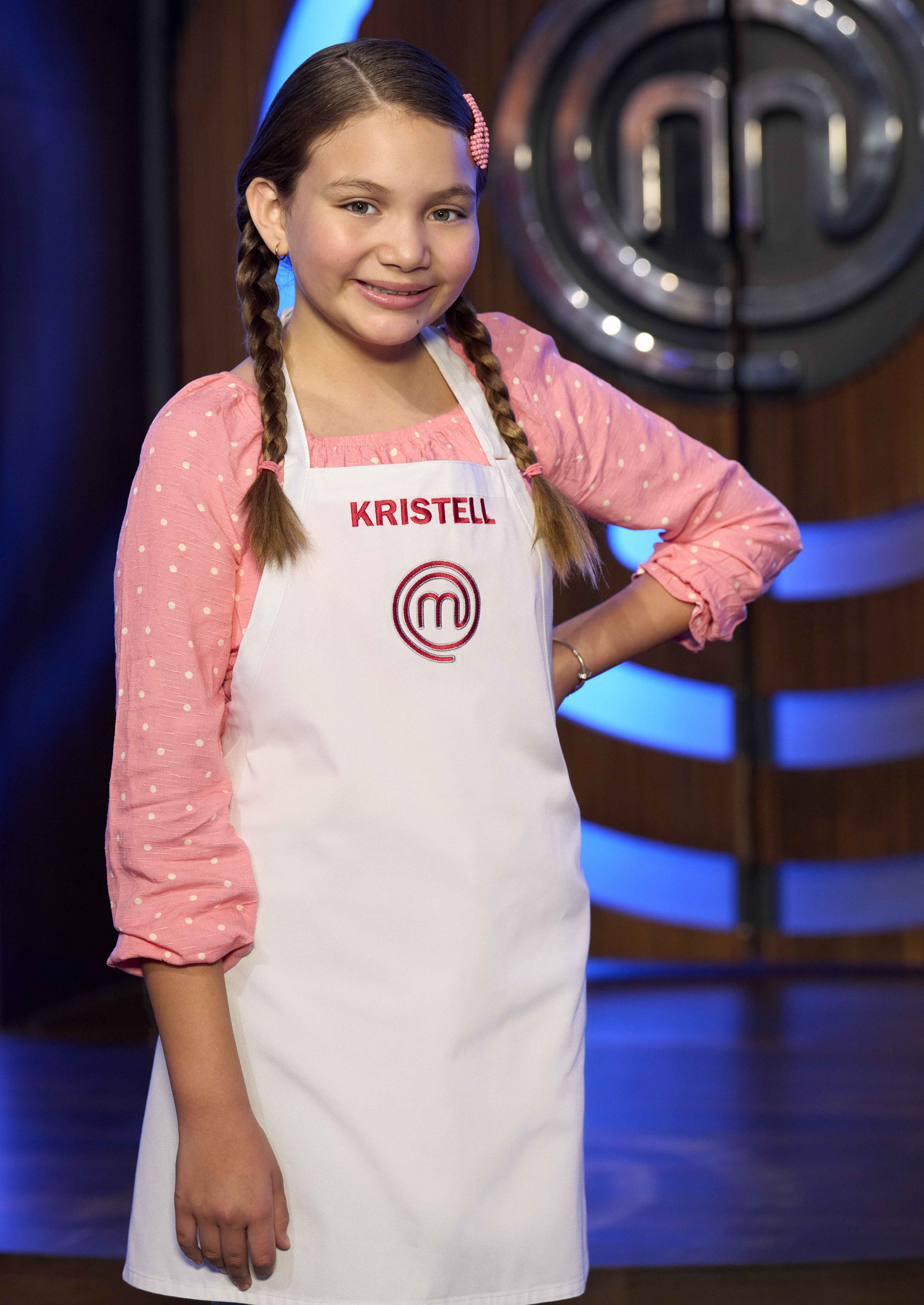 A young girl wearing an apron that says “Kristell.”