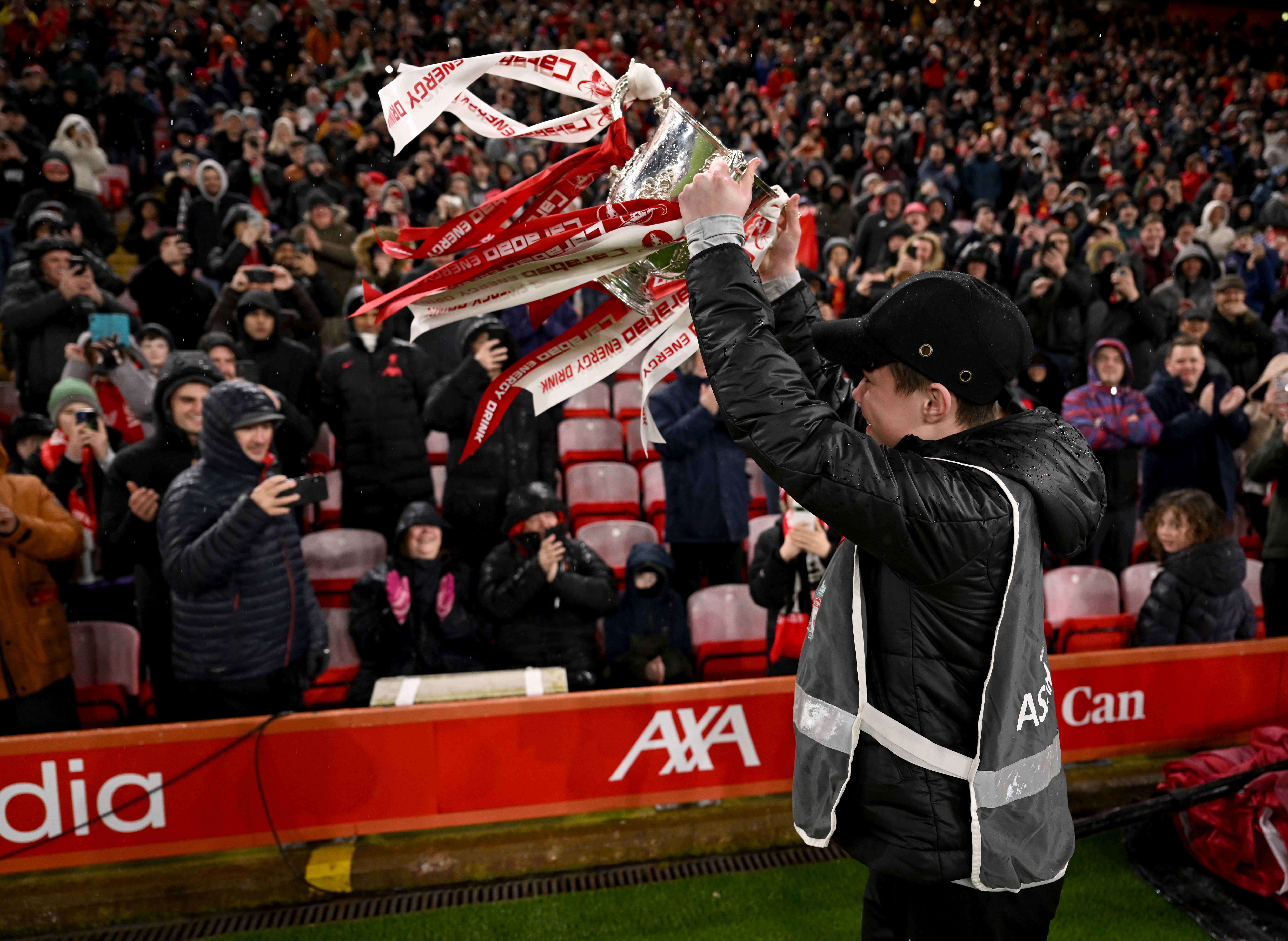 Liverpool ball boys bringing the Carabao Cup out for a lap of honour before the Emirates FA Cup Fifth Round match between Liverpool and Southampton at Anfield on February 28, 2024 in Liverpool, England.