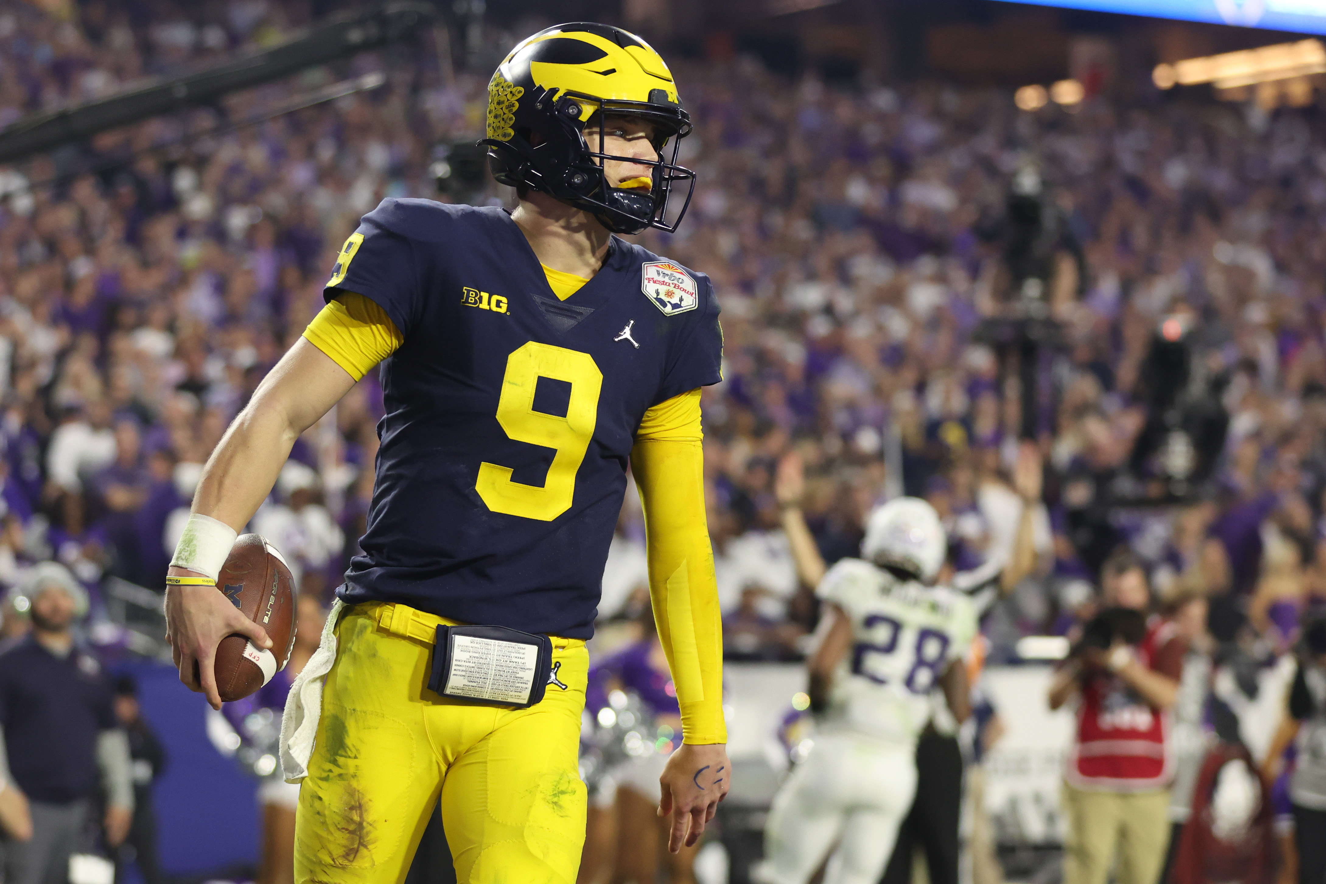 J.J. McCarthy #9 of the Michigan Wolverines reacts after rushing for a touchdown during the third quarter against the TCU Horned Frogs in the Vrbo Fiesta Bowl at State Farm Stadium on December 31, 2022 in Glendale, Arizona.