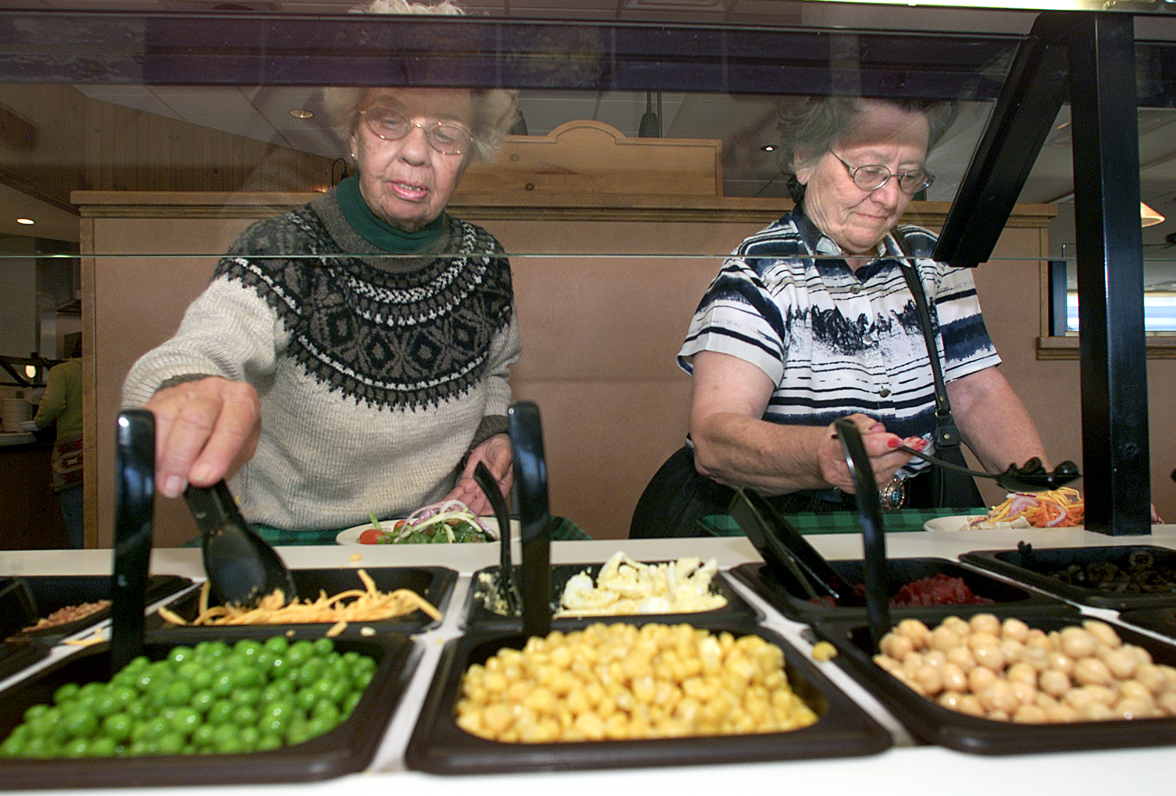 June Ross, left, from Lancaster, and friend Barbara Murray, from Victorville, fill their plates up w
